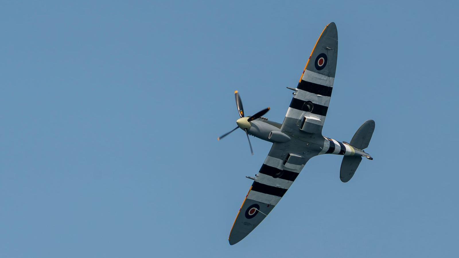 A spitfire flying in clear blue skies