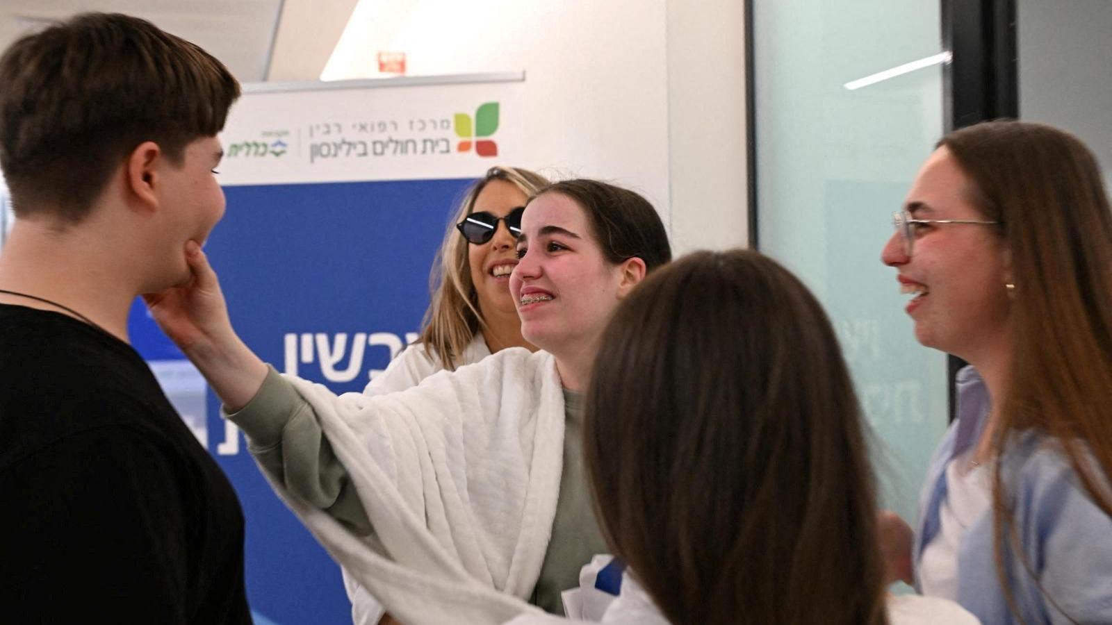 Agam Berger embraces a male family member as she's reunited with her family at a facility in Petah Tikva, Israel on 30/1/2025