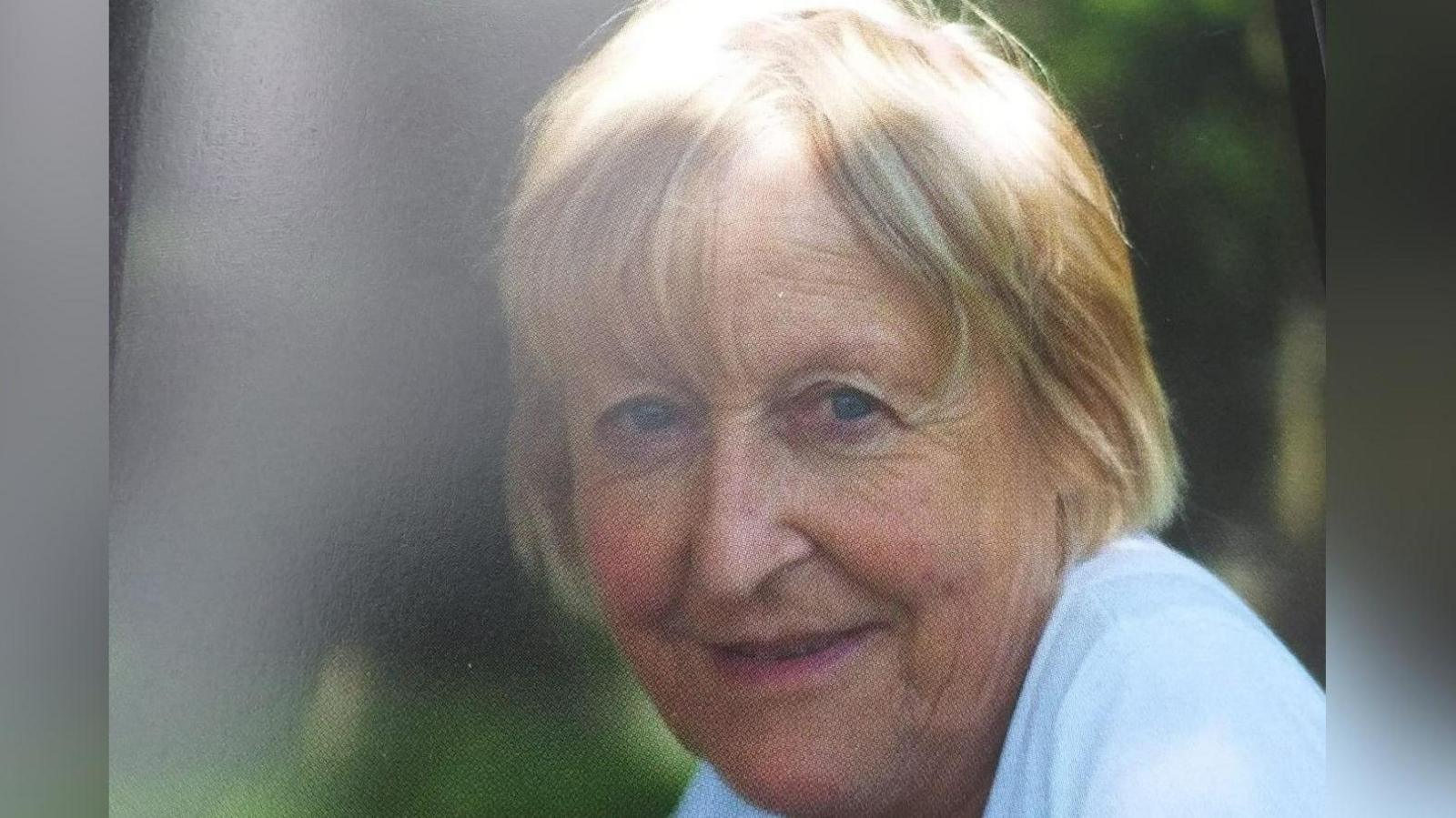 A tightly-cropped portrait of Rachael Heyman. She has blond hair in a short bob and blue eyes. She is looking at the camera and smiling.