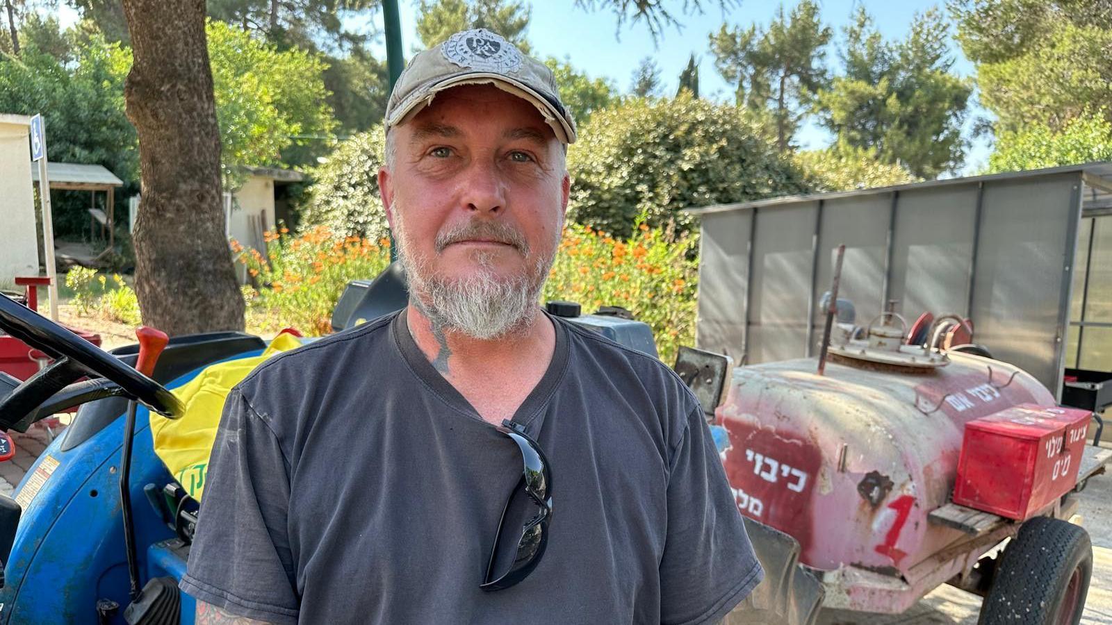 Dean Sweetland stands in front of make-shift fire-fighting equipment in Kibbutz Malkiya, northern Israel