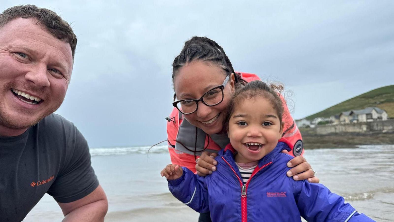 Lewis, Rachel and their daugter Winnie on a beach