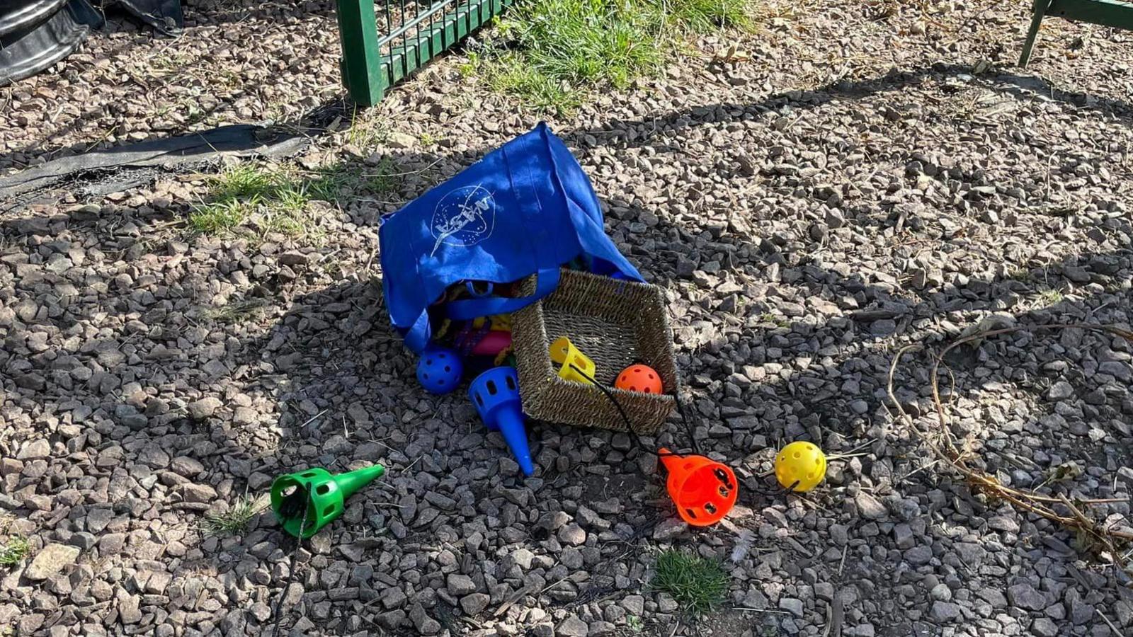 Children's toys and outdoor games are dumped and strewn across the ground.