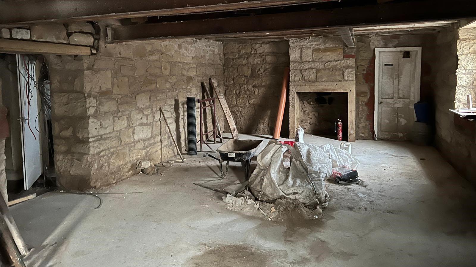 A scene or renovation with a concrete floor and a wheelbarrow