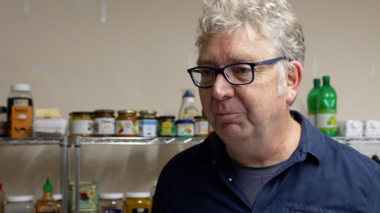 Restaurateur and food writer Simon Wright, wearing a blue shirt, in a kitchen