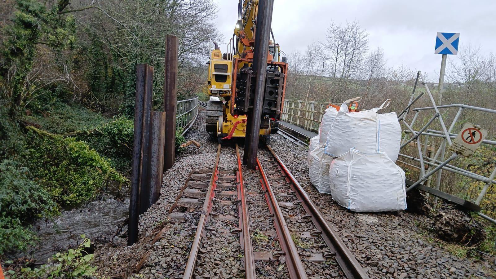 A picture of the track on the line between Newquay and Par. Machinery can be seen alongside the bags of rocks.