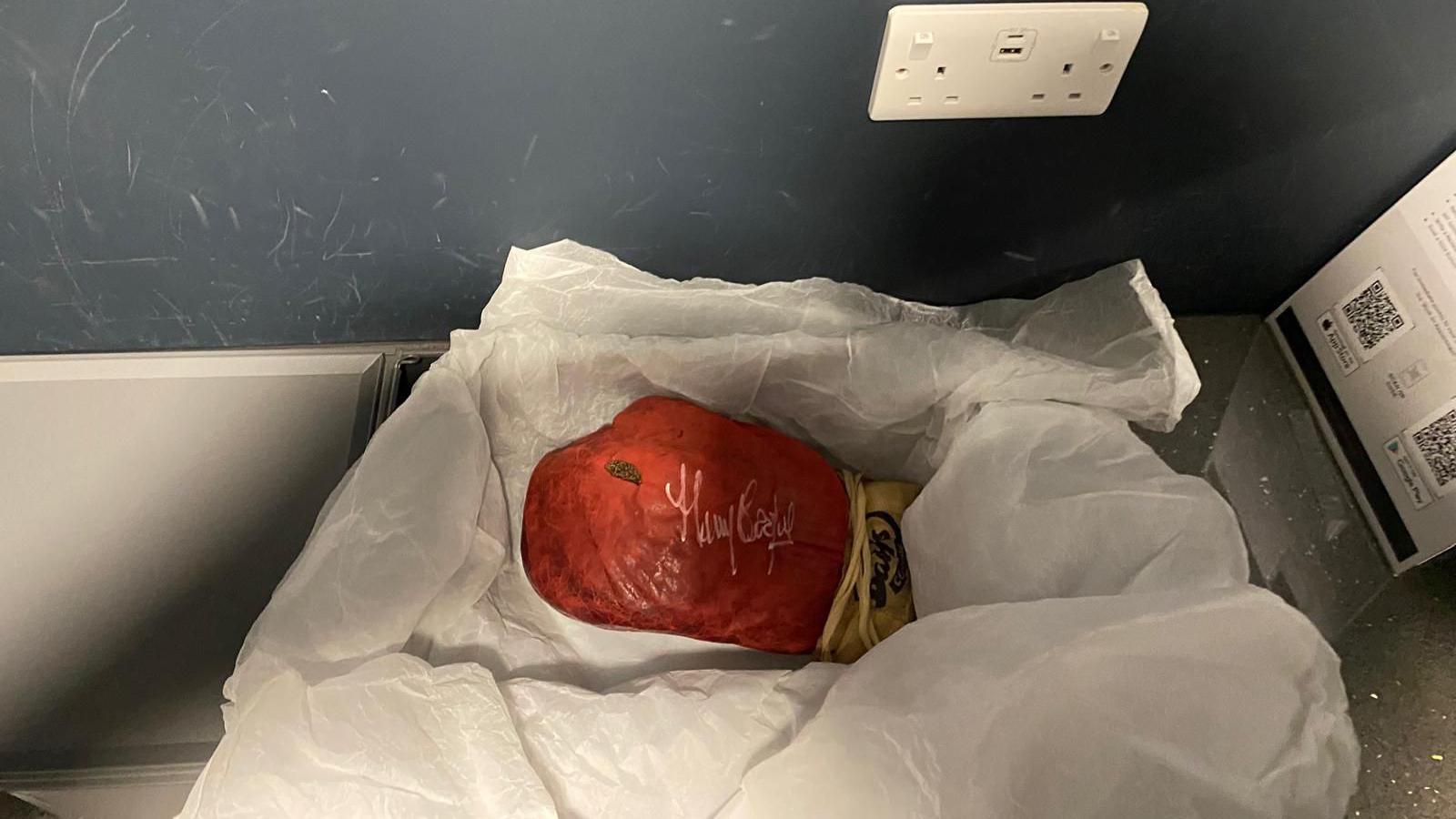 A red boxing glove worn by Mohammed Ali sits in white packaging inside a vault at a secret location.