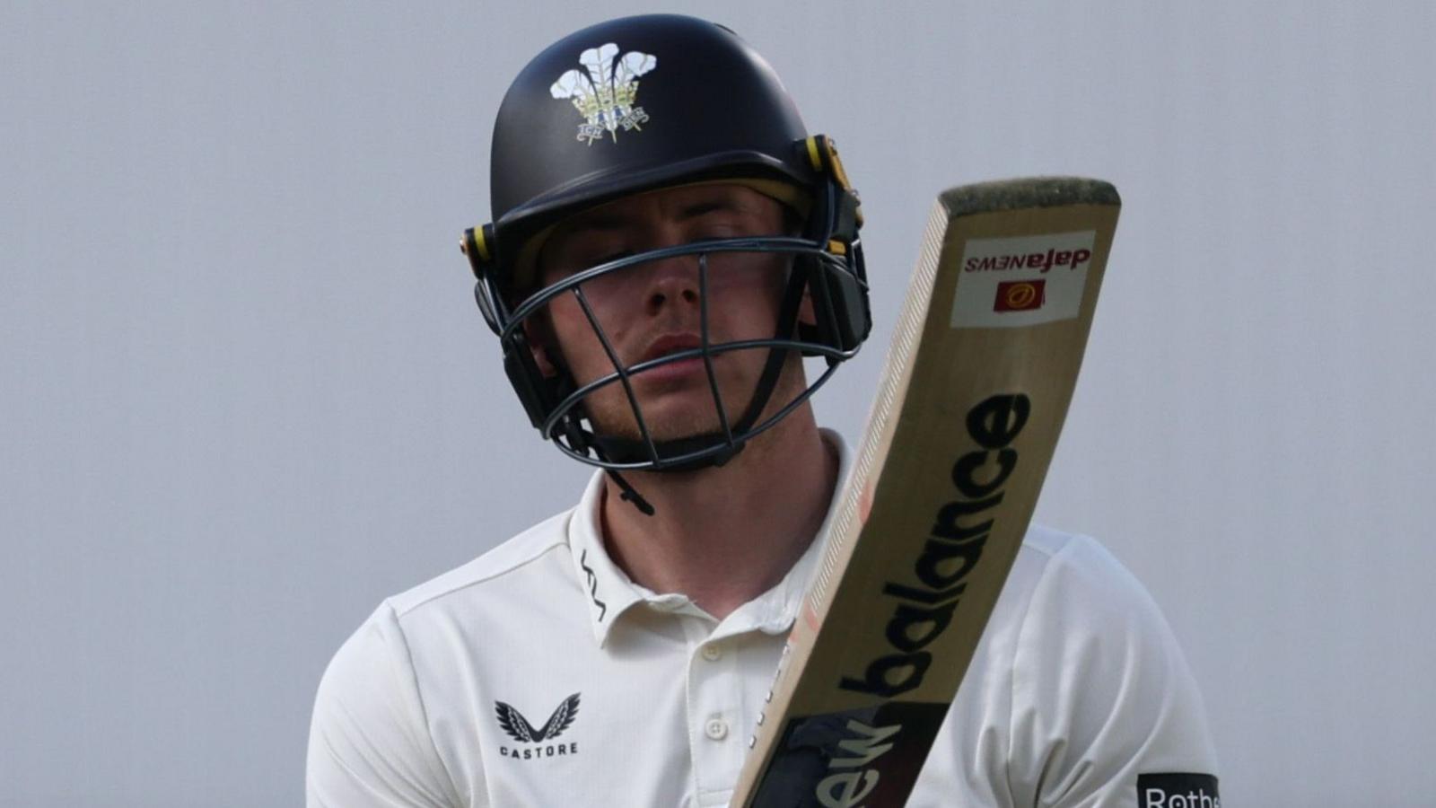 Jamie Smith raises his bat to the crowd