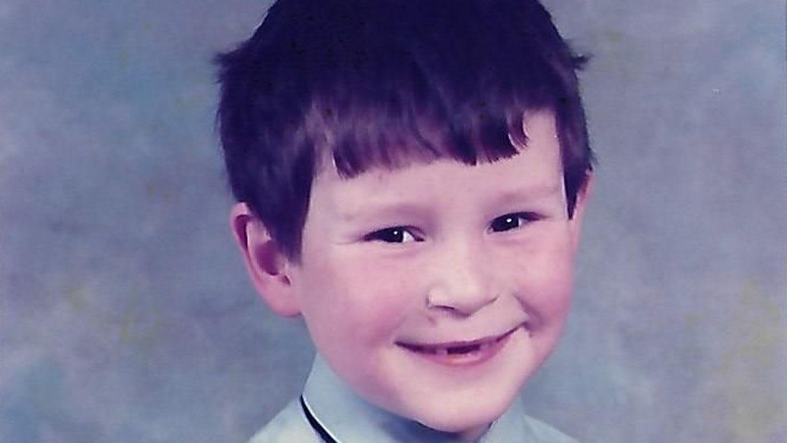 A school picture of Danny Leech - he has dark hair and is smiling mischievously at the camera