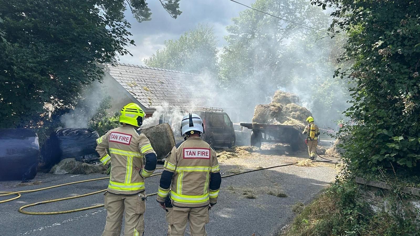 Diffoddwyr yn delio gyda'r tân sydd yn agos iawn at dy cyfagos