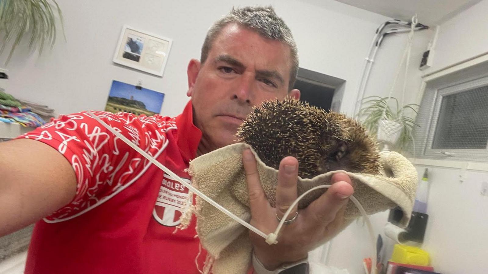 Steve Byrne holding the hedgehog and the cut cable tie after it was removed