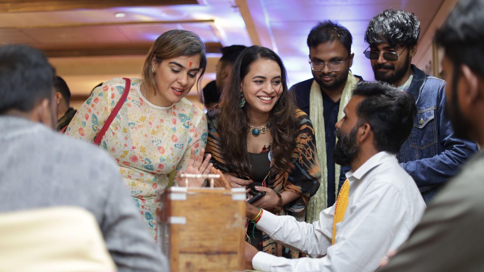 People wearing traditional Indian clothes participate in games at a fake wedding party 