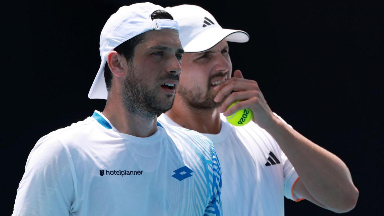 Julian Cash and Lloyd Glasspool discuss tactics during their Australian Open second-round match