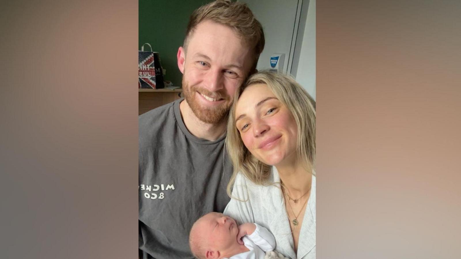 Becki and James are taking a selfie while holding their newborn baby boy Beauden.