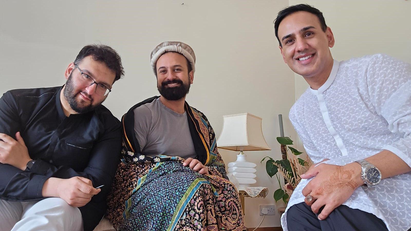 Fehran with two friends pose for the camera at home in their cultural dress