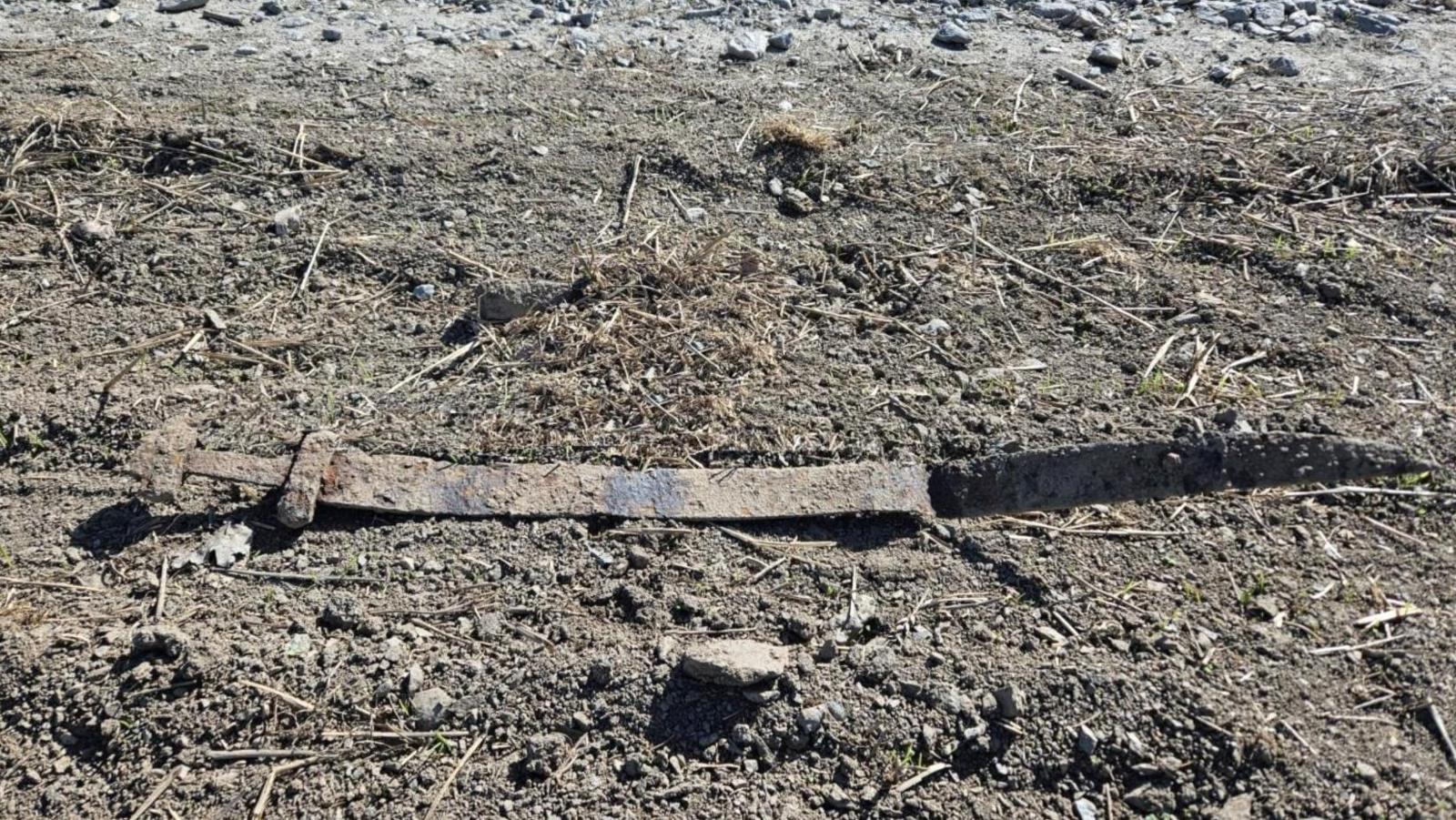an ancient rusty viking-age sword on some mud