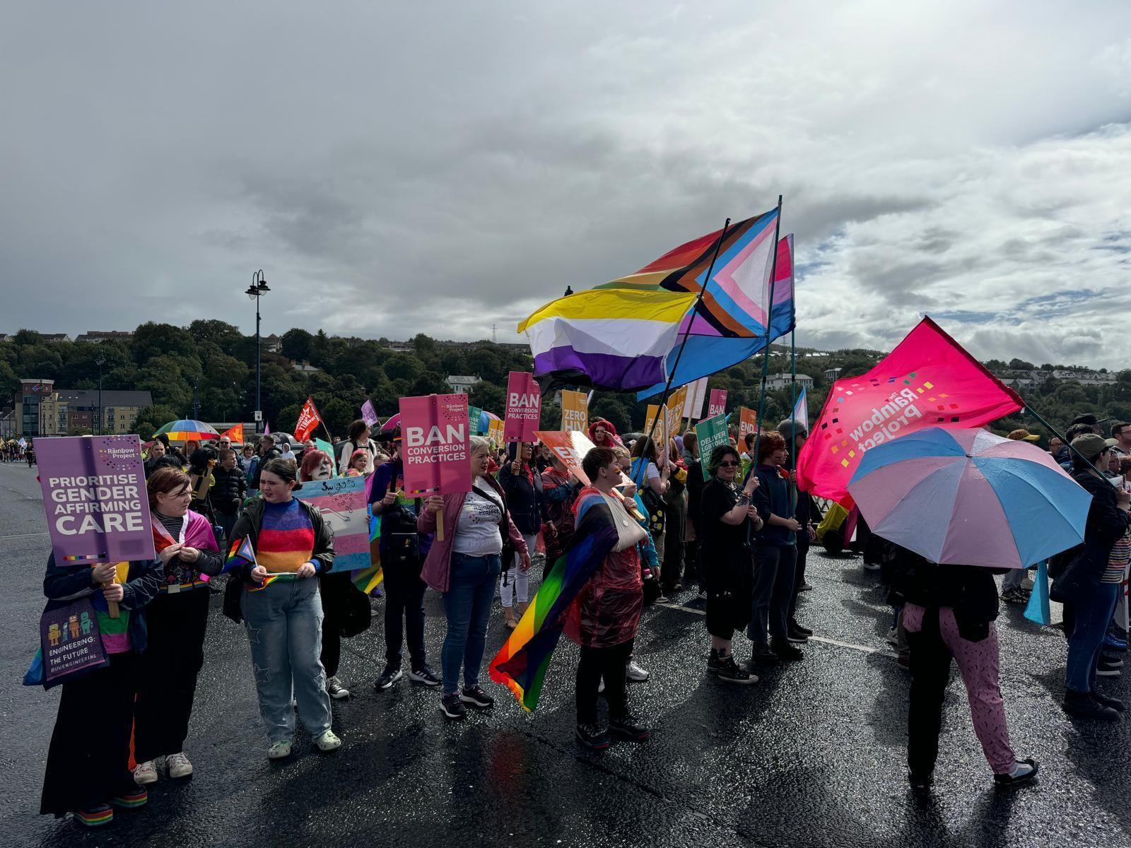 Crowd at Foyle Pride holding colourful Pride flags