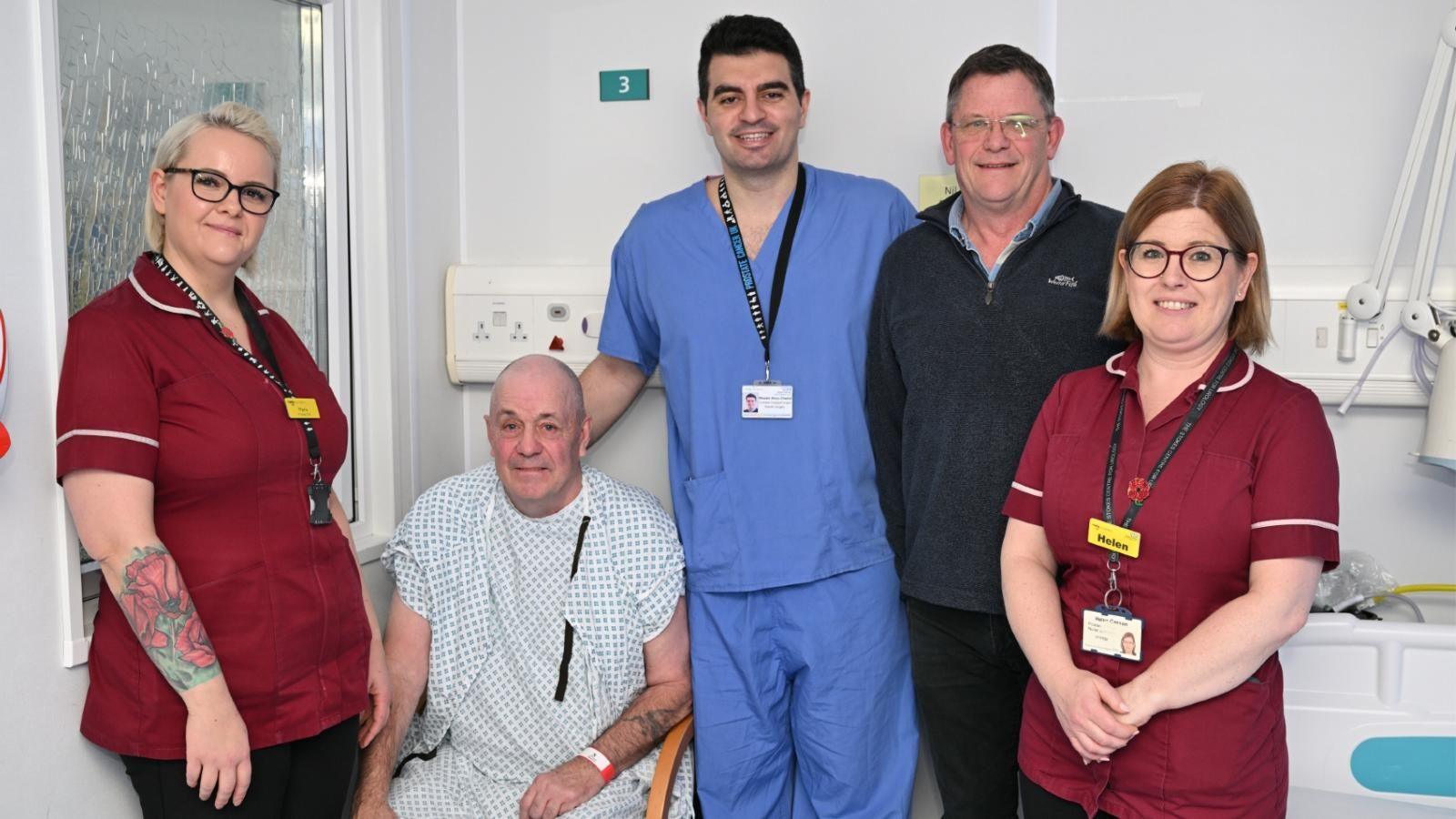 Hospital staff gather around a patient and his brother. 