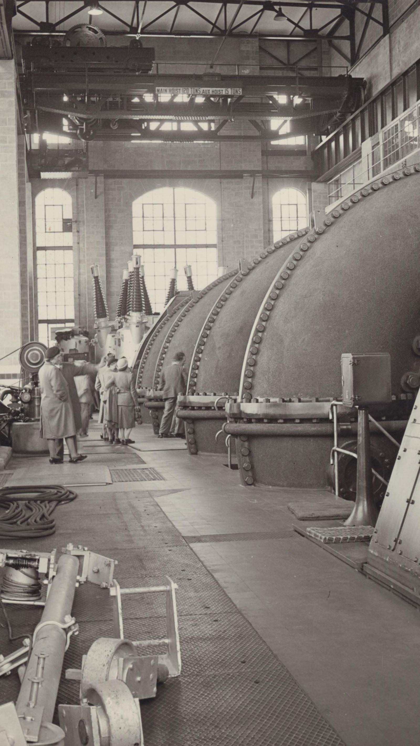 Tummel power station's original turbines were large domes, several times taller than the people standing near them in a hall