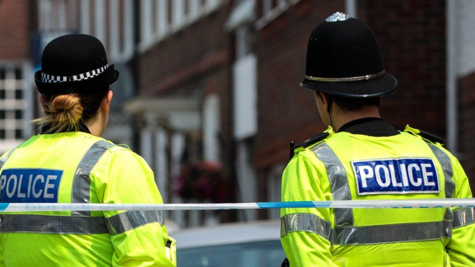 Female and male officers behind police tape