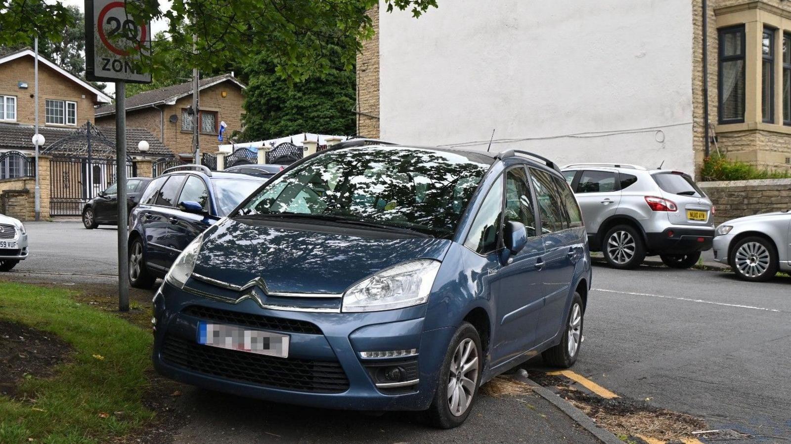 A car parked diagonally on a path.
