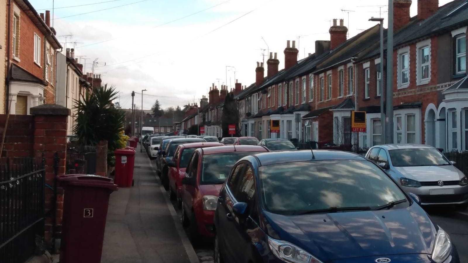 A terraced street with bins on the pavement