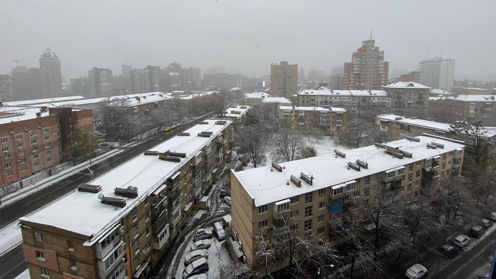 Snow covers several blocks of flats along with cars