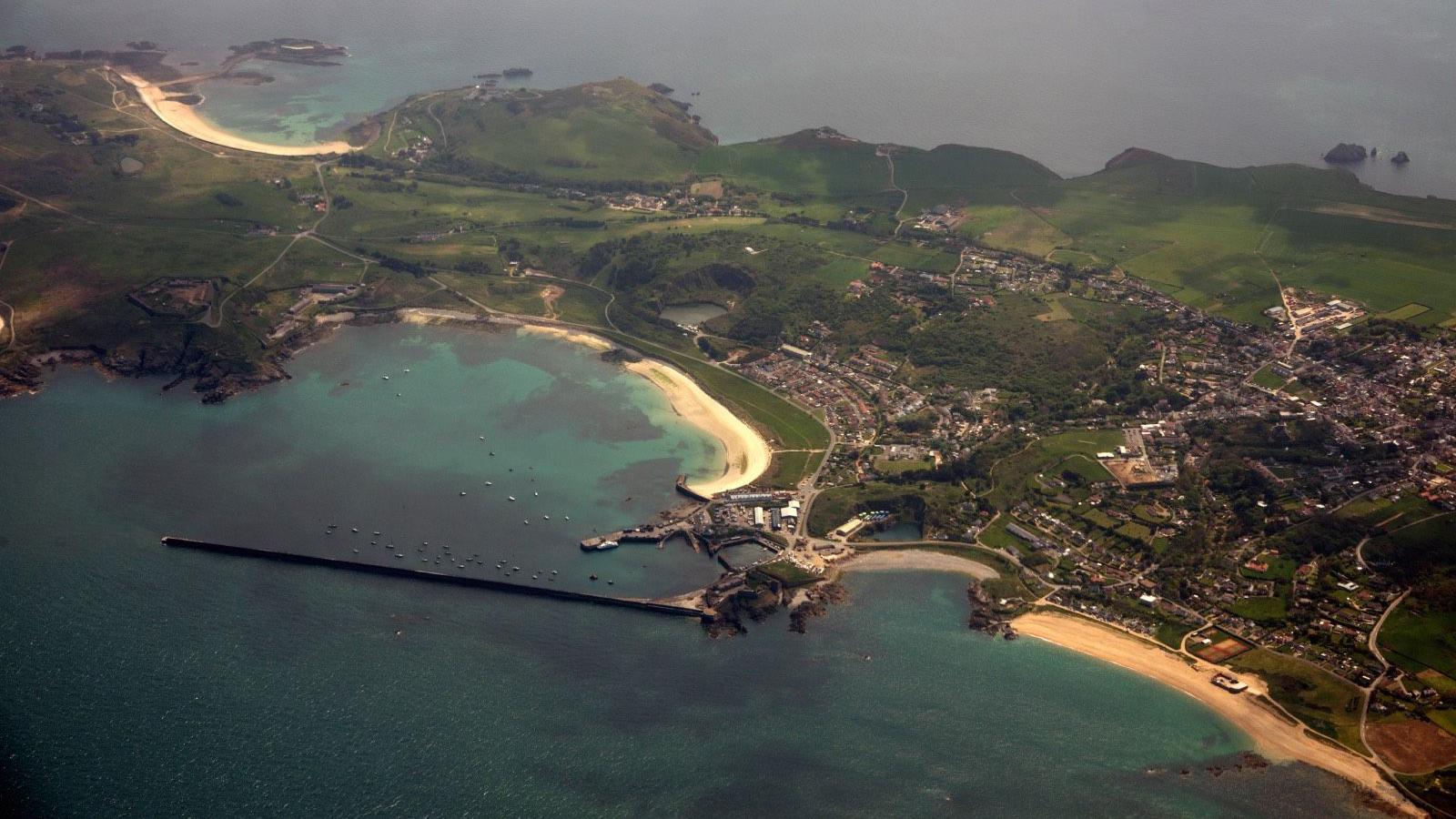 A view of Alderney from the air. A small island with yellow sandy beaches.