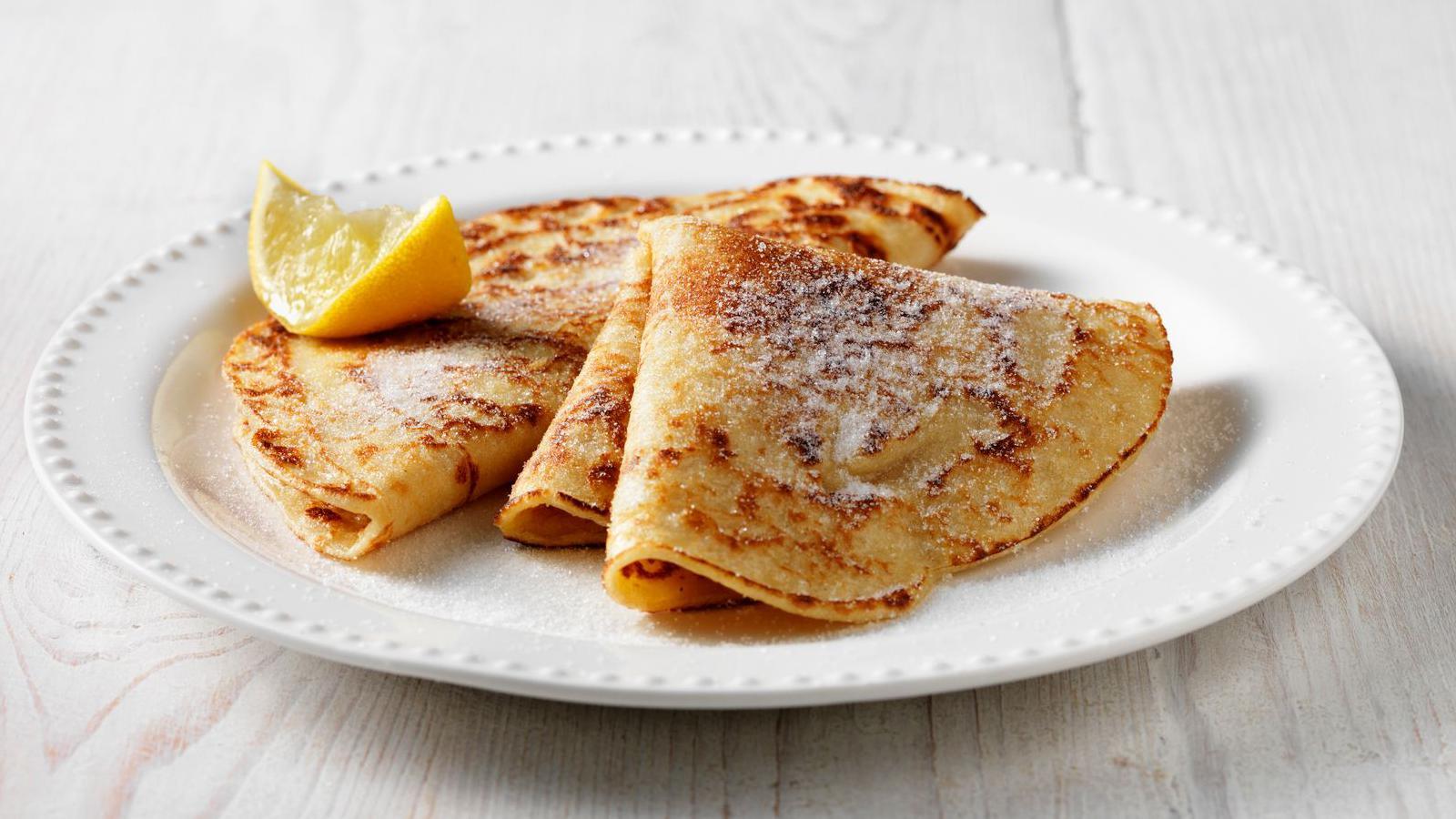 Pancakes on a plate with lemon and sugar