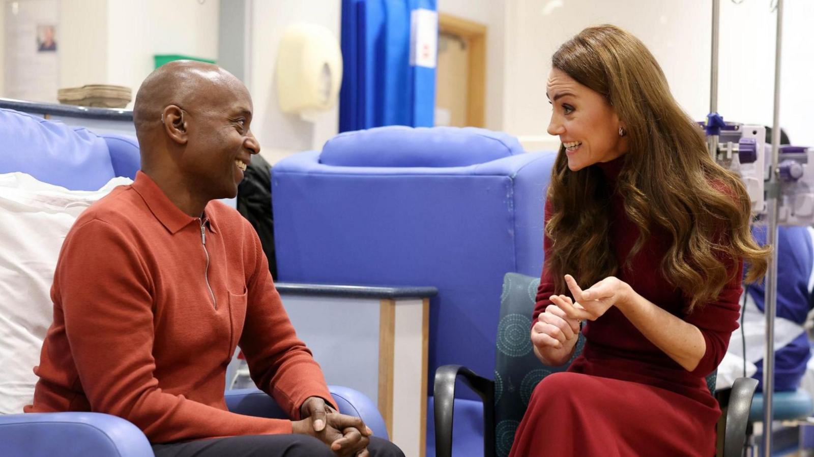 The Princess of Wales speaks to a man sitting in a chair inside the Royal Marsden Hospital