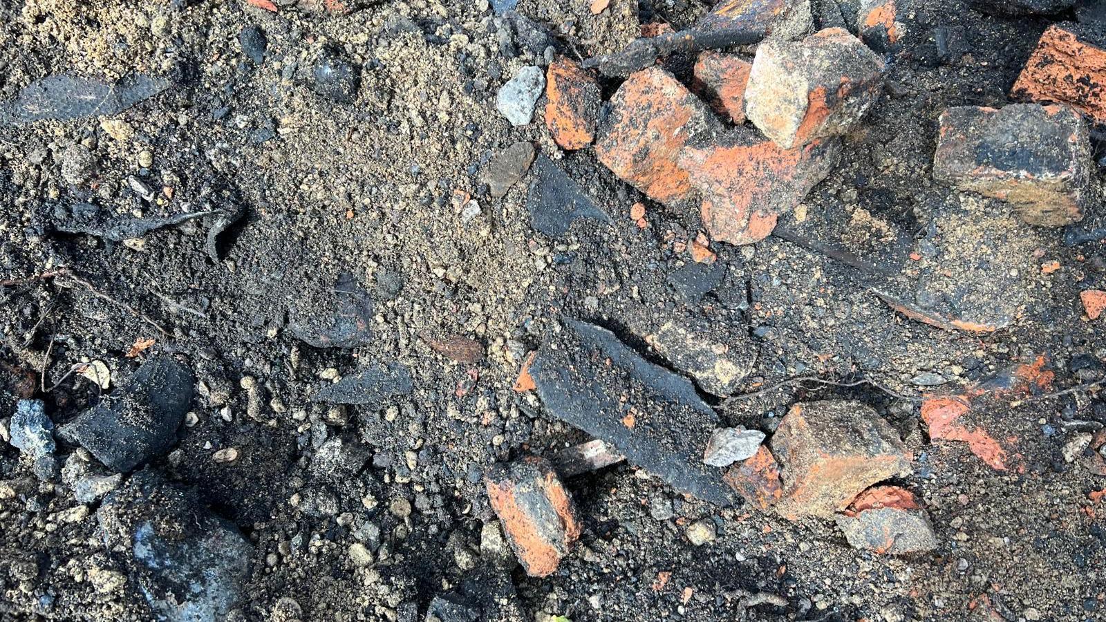 A closeup of shards of asbestos among other substances in the ground