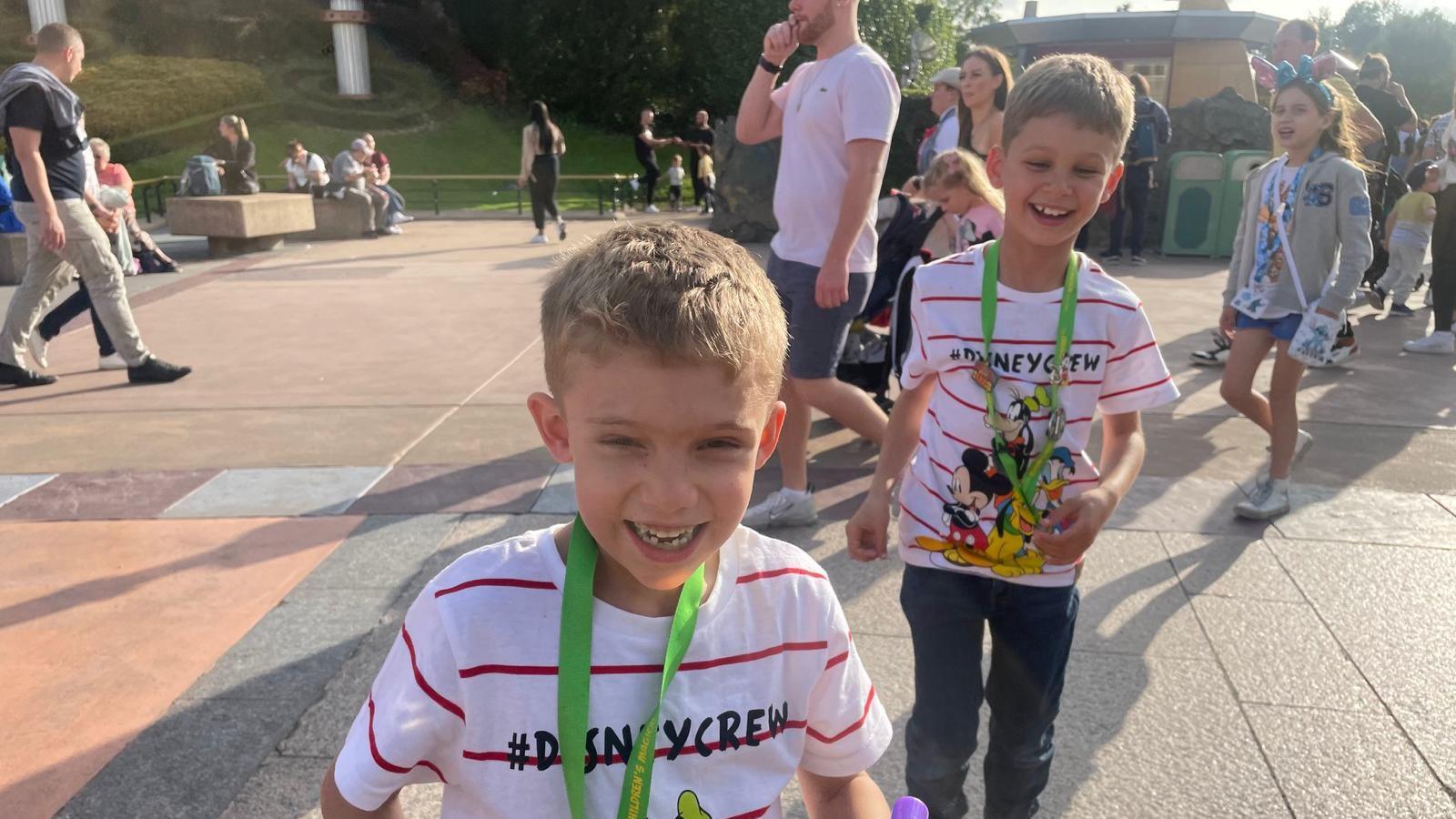 Brothers Rhys and Benjamin wear Disney shirts in the grounds of Disneyland Paris.