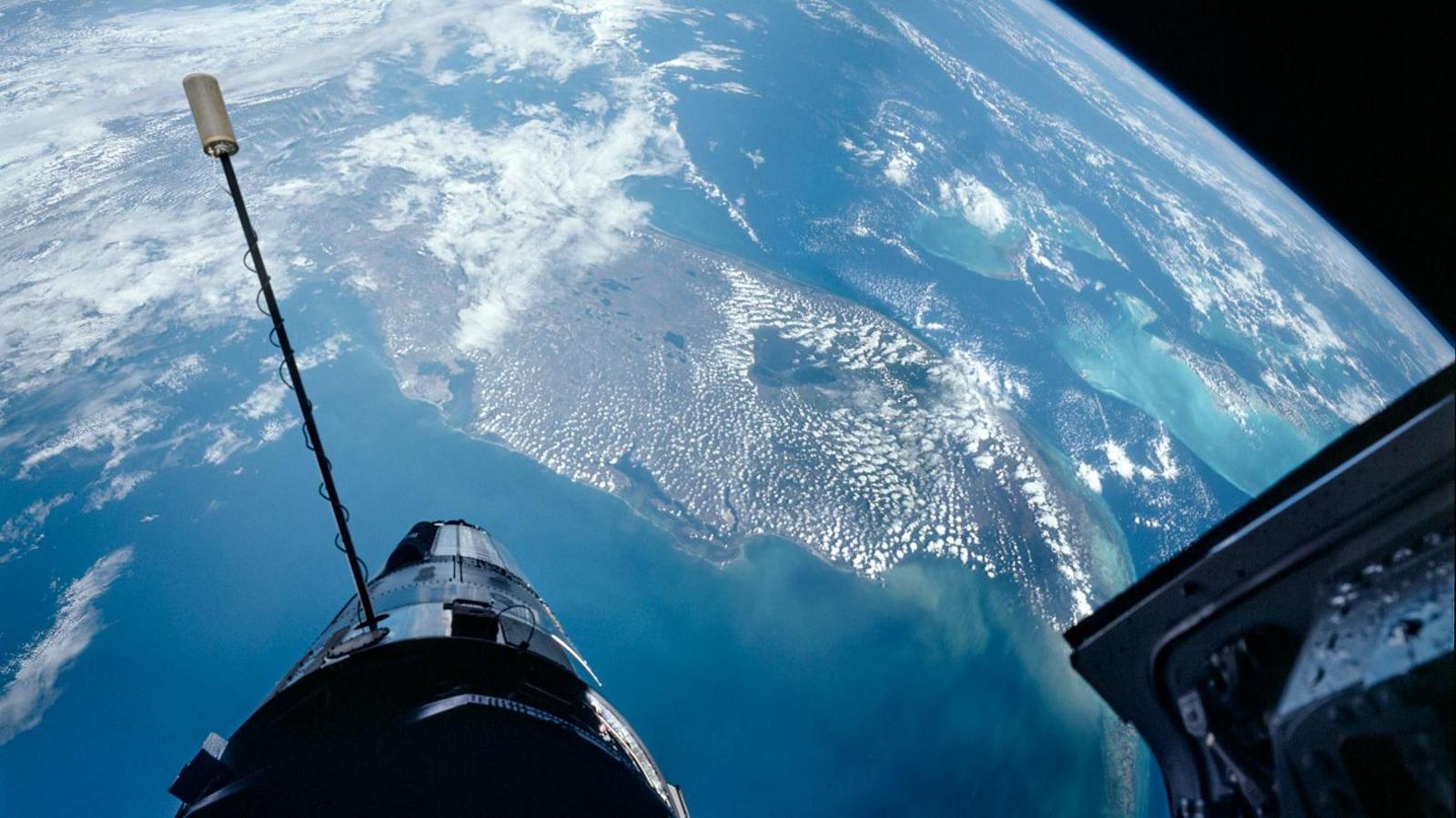 The earth as seen from space. The open door of a spacecraft is in the right corner of the image. 