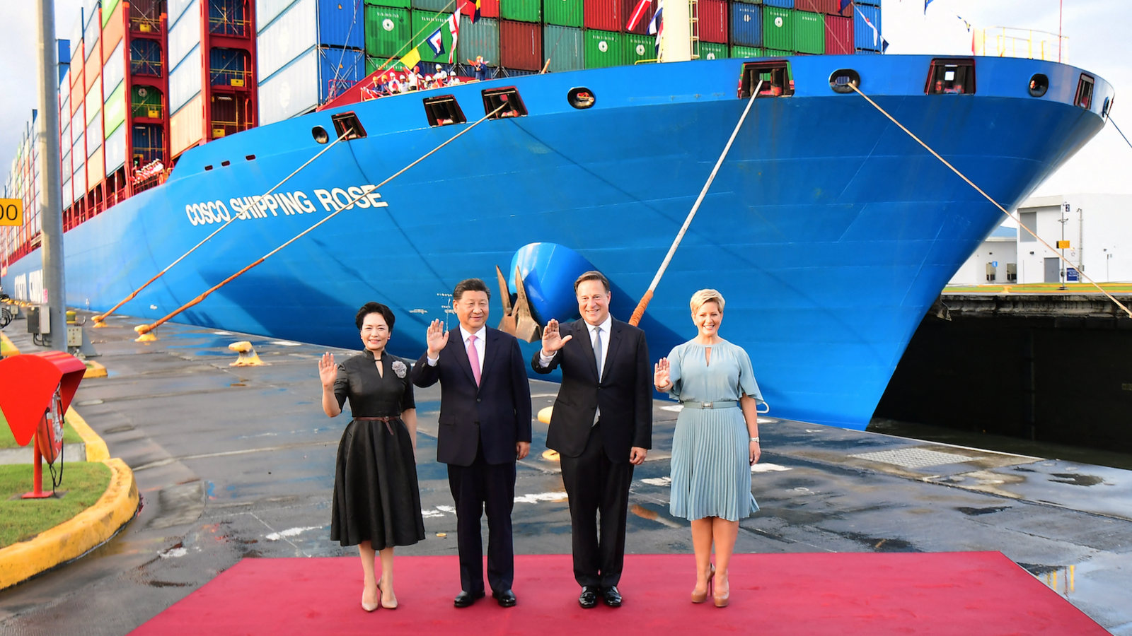 China's President Xi Jinping and Panama's Juan Carlos Varela, wearing dark suits and ties, stand between the nations' First Ladies in formal dresses, in front of a big blue Chinese container vessel at the Cocoli locks in the Panama Canal, on 3 December 2018. 