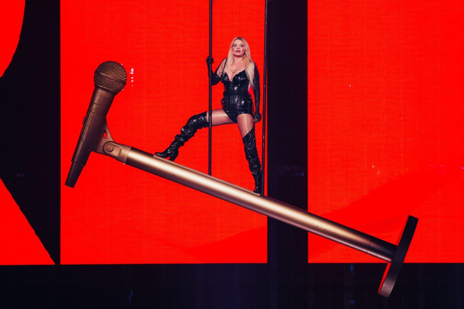 Erika Vikman stands atop a giant golden microphone as she performs at the Eurovision Song Contest