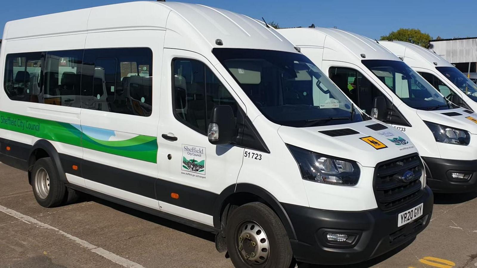 White minibuses parked side by side bearing a Sheffield City Council logo