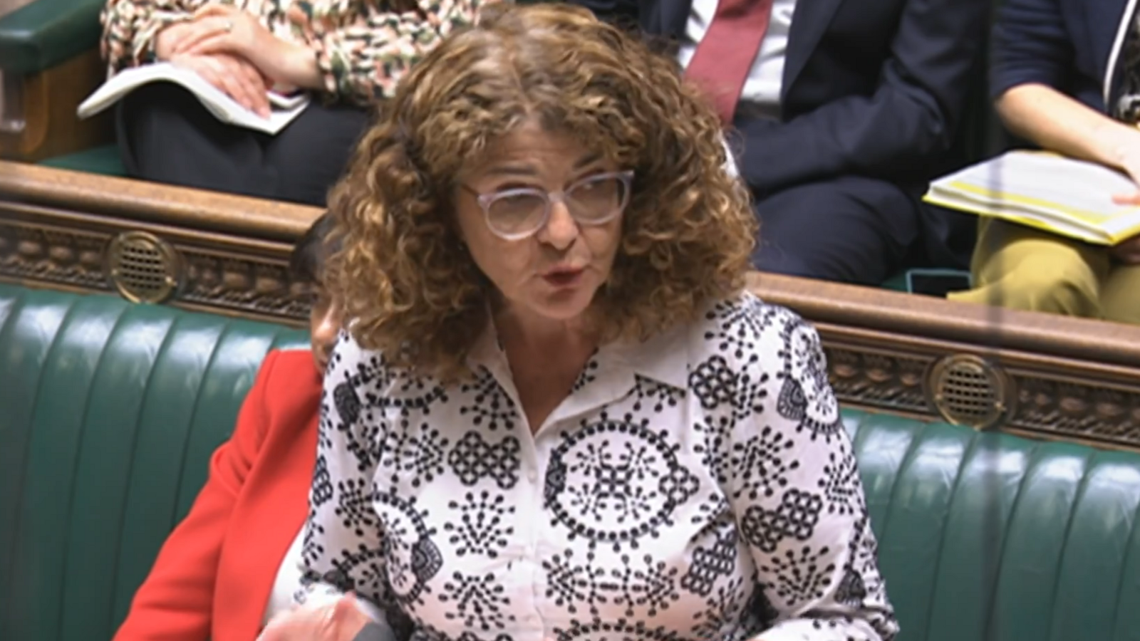 The minister, wearing a black and white blouse, stands at the government front bench in the Commons 