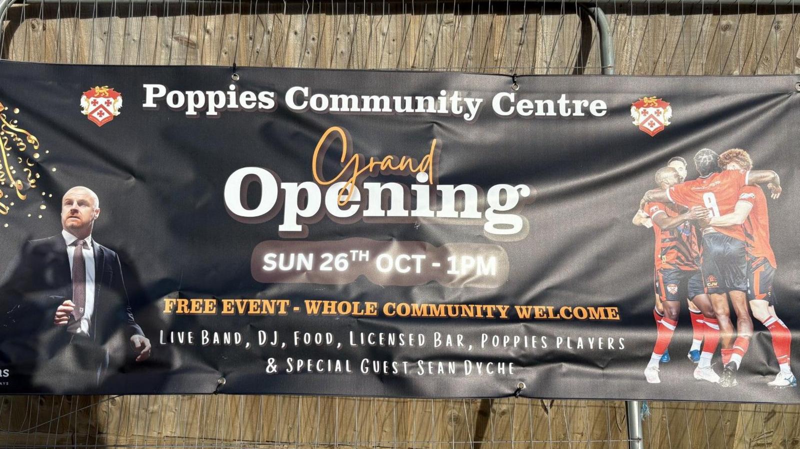 A Grand Opening poster, with an image of Sean Dyche, to the left, four football to the right, on a metal frame.