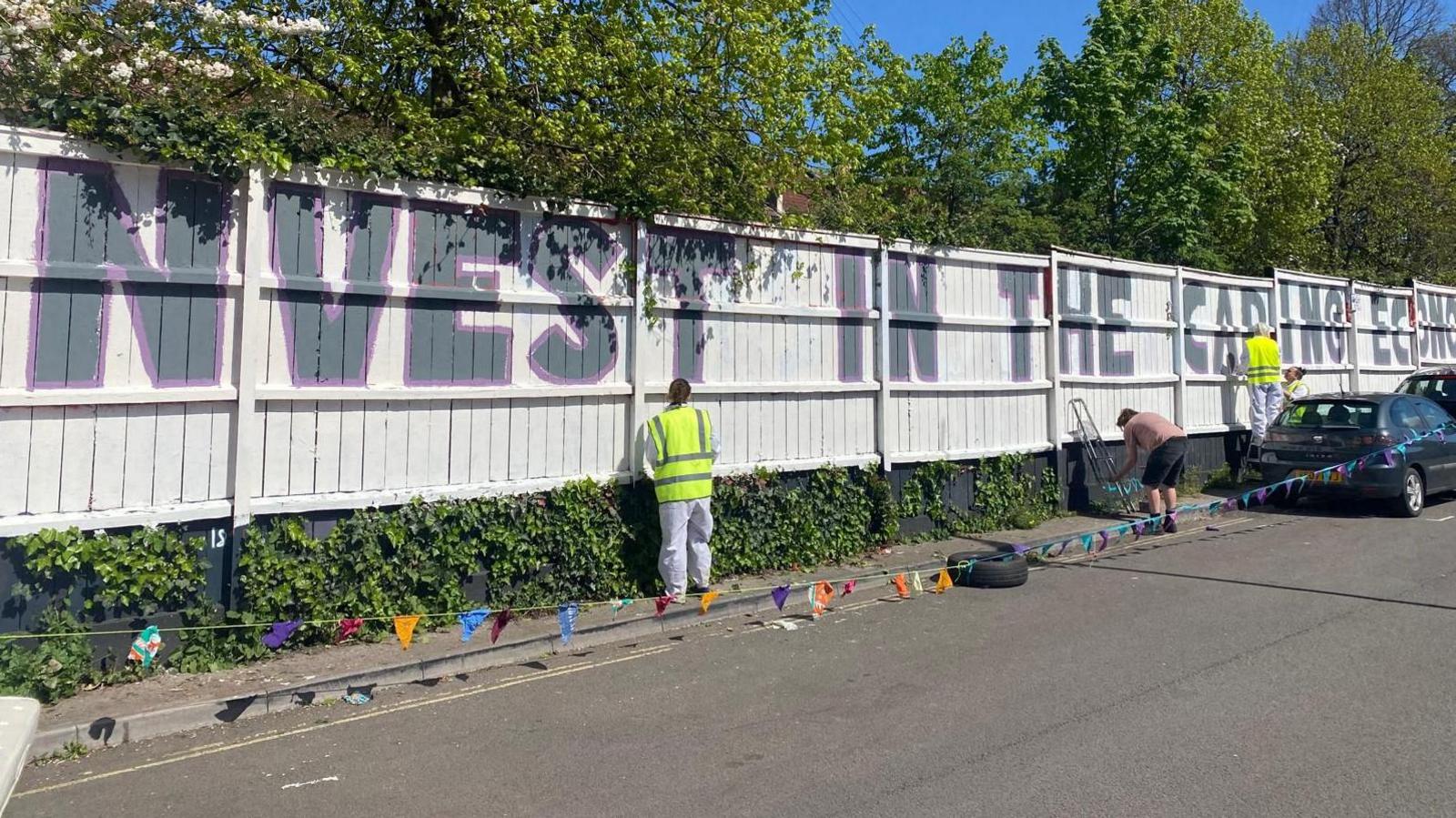 People painting the mural on the wall on Gatton Road