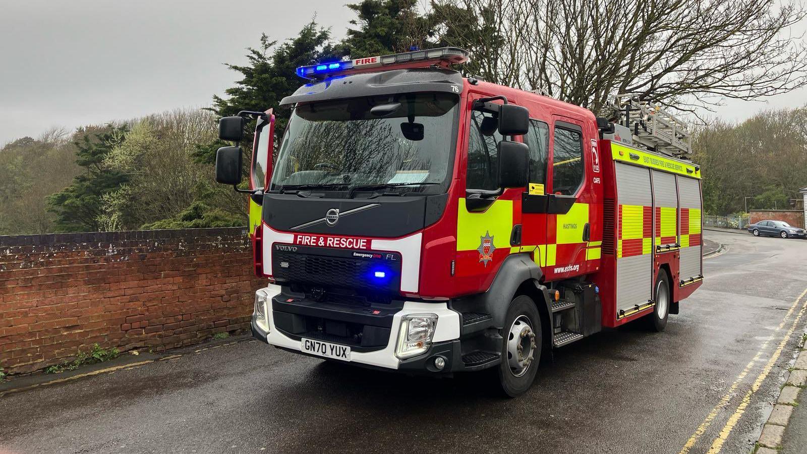 A red and yellow fire engine parked on a road.