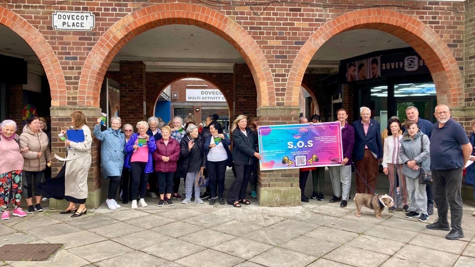 A group of dozens of campaigners gathered outside Dovecot and Breck Road Libraries.