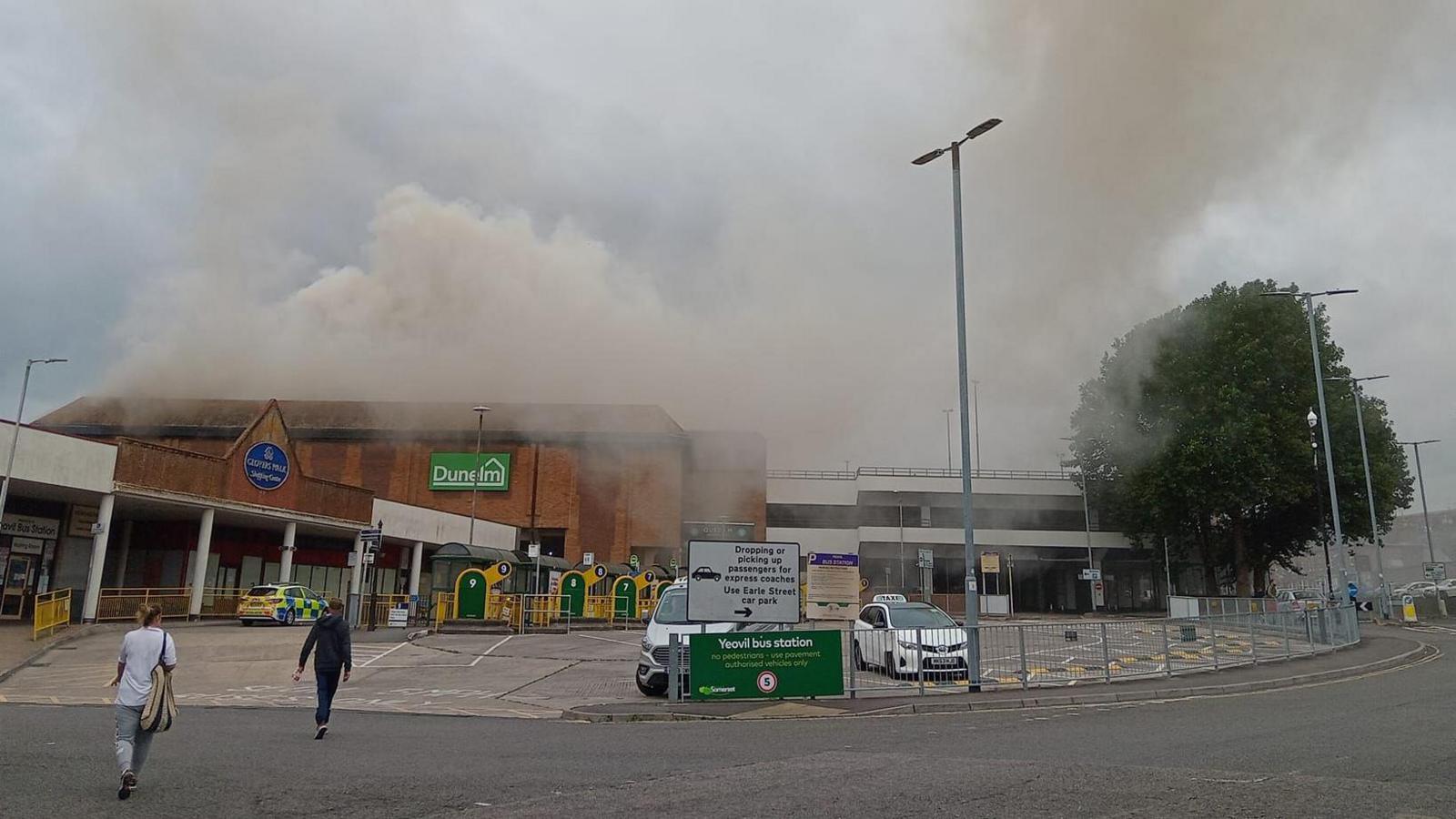 The outside of the Dunelm store in Yeovil. Grey smoke can be seen coming from the roof.