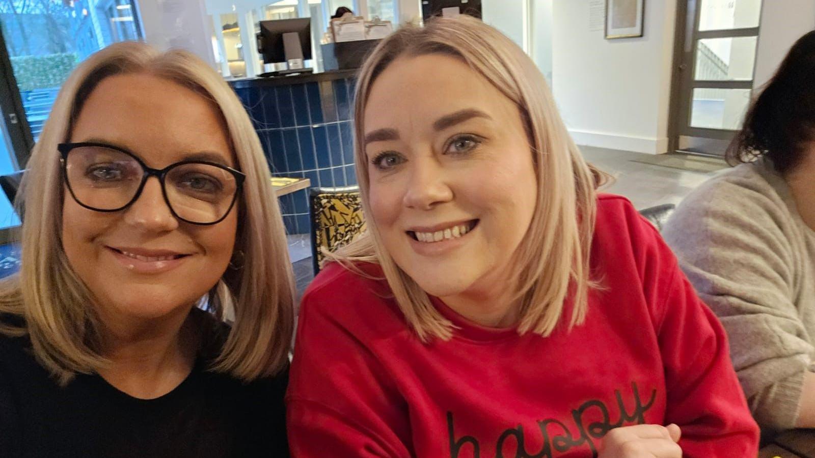 Mary and Sharon Donaghy taking a selfie as they sit down at a restaurant.