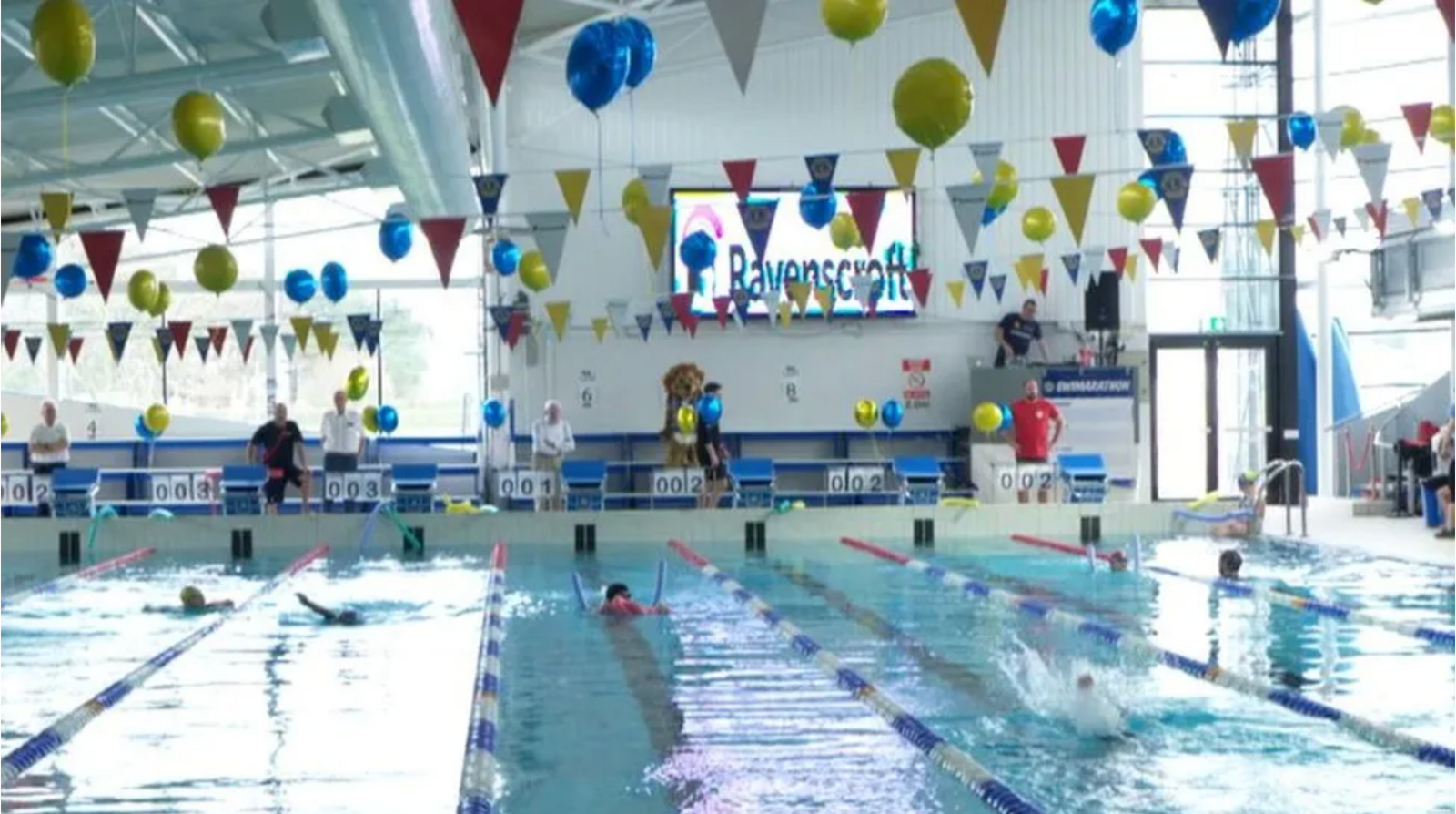 Swimming pool with multiple lanes and balloons and bunting for the swimarathon.