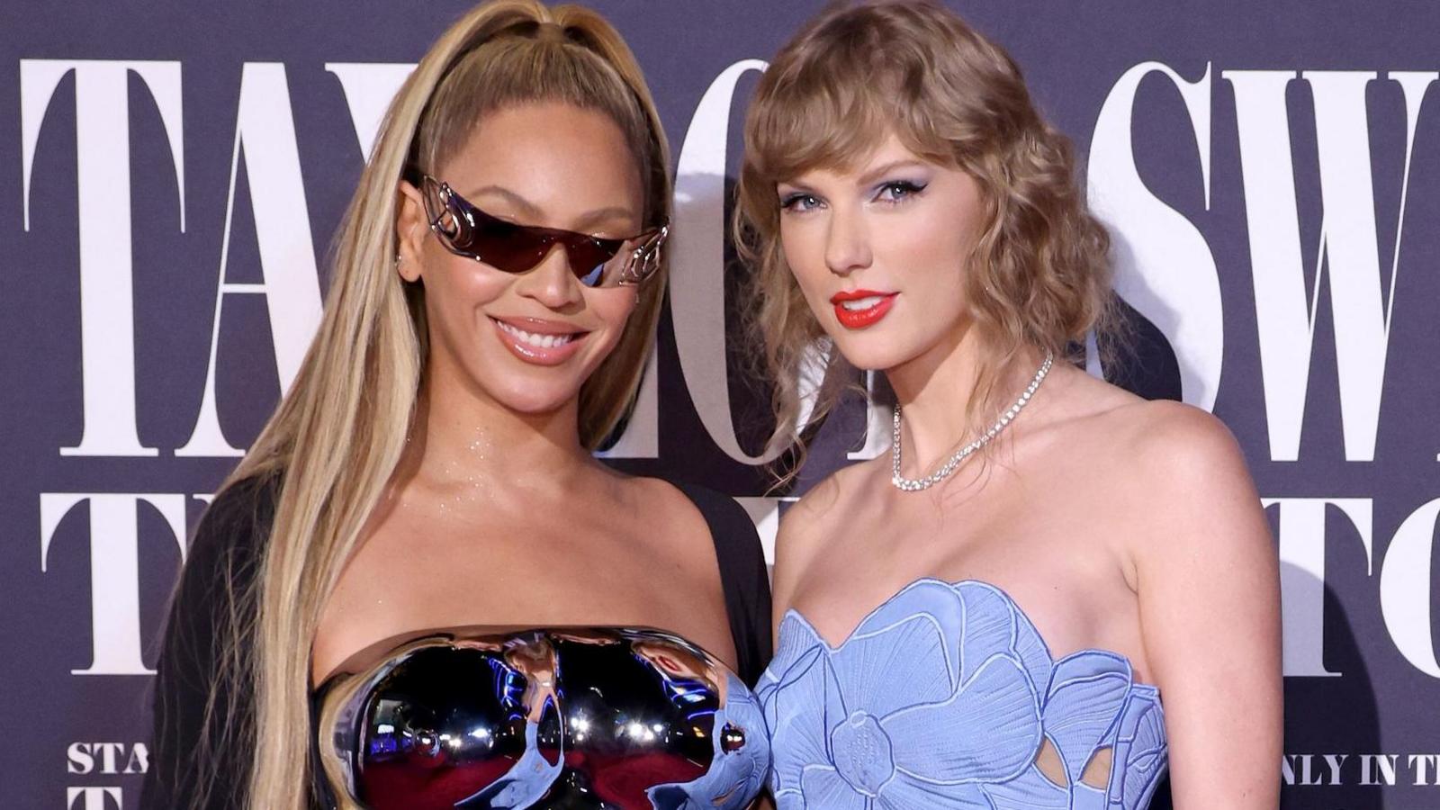 Beyoncé and Taylor Swift pose at the US premiere of Swift's concert movie in 2023; both are in strapless gowns and are smiling