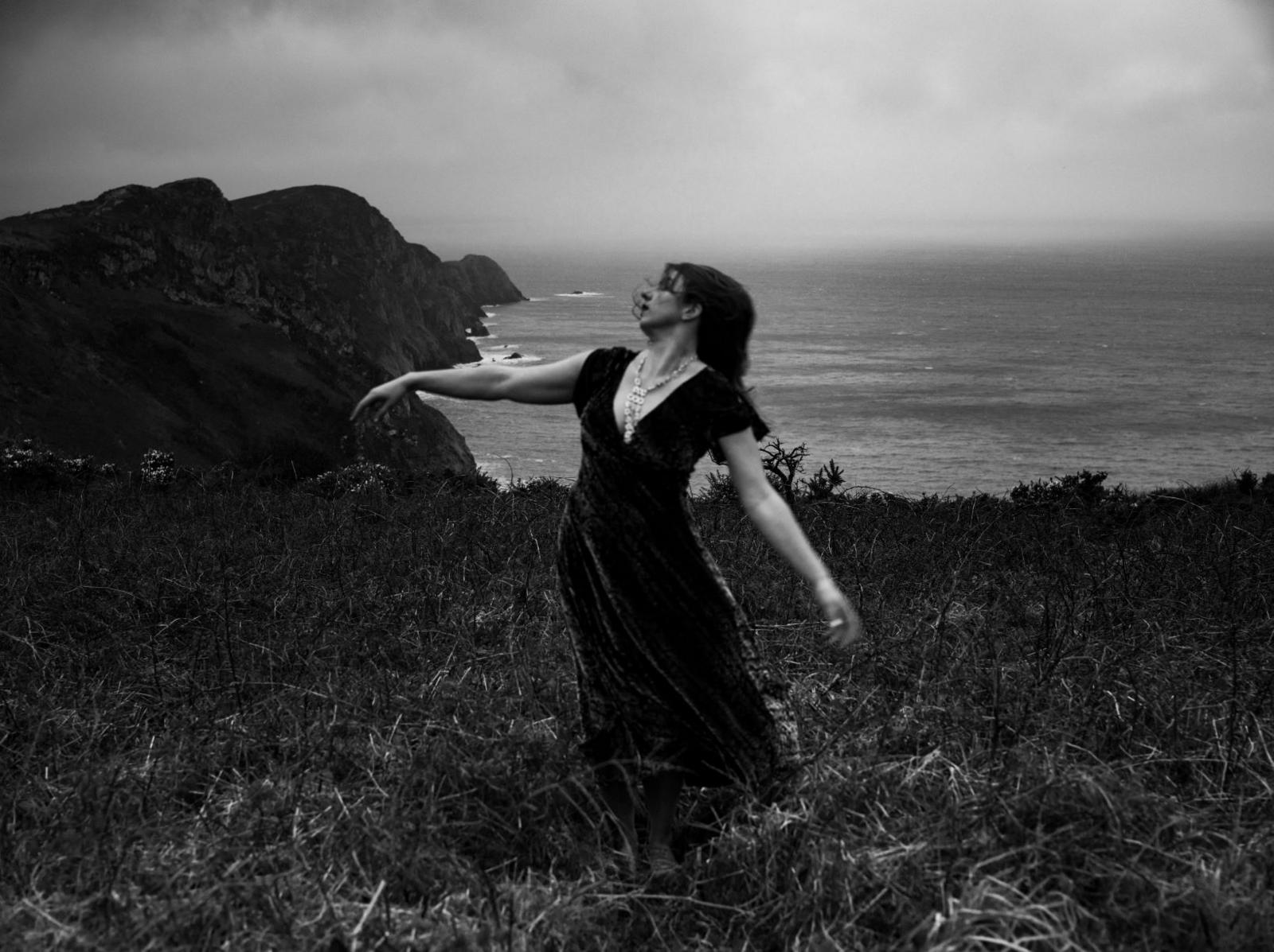 A woman dancing on a Welsh coastal path at Cwm Dewi