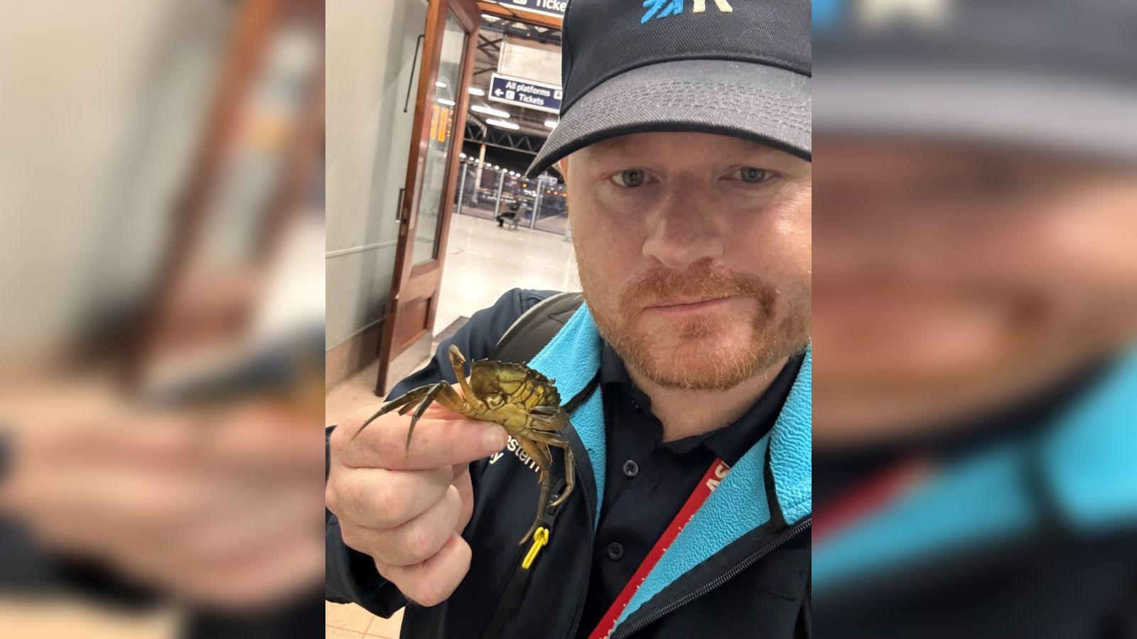 A train driver holds a crab