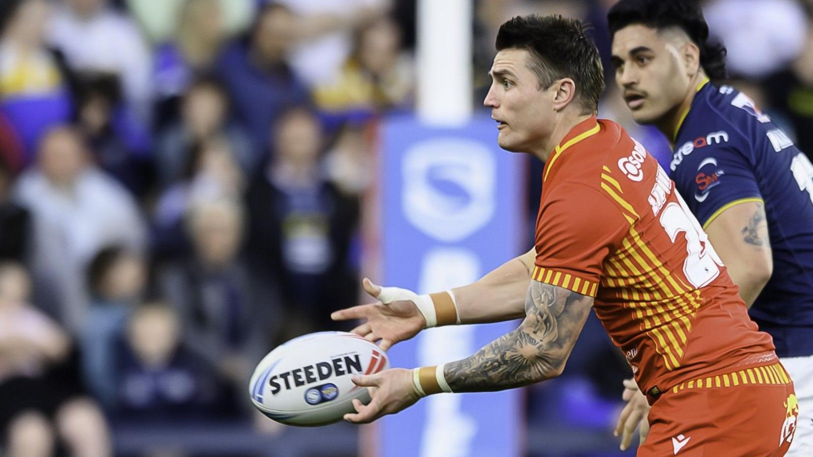 Zac Lipowicz throws a pass wearing a red Catalans Dragons kit