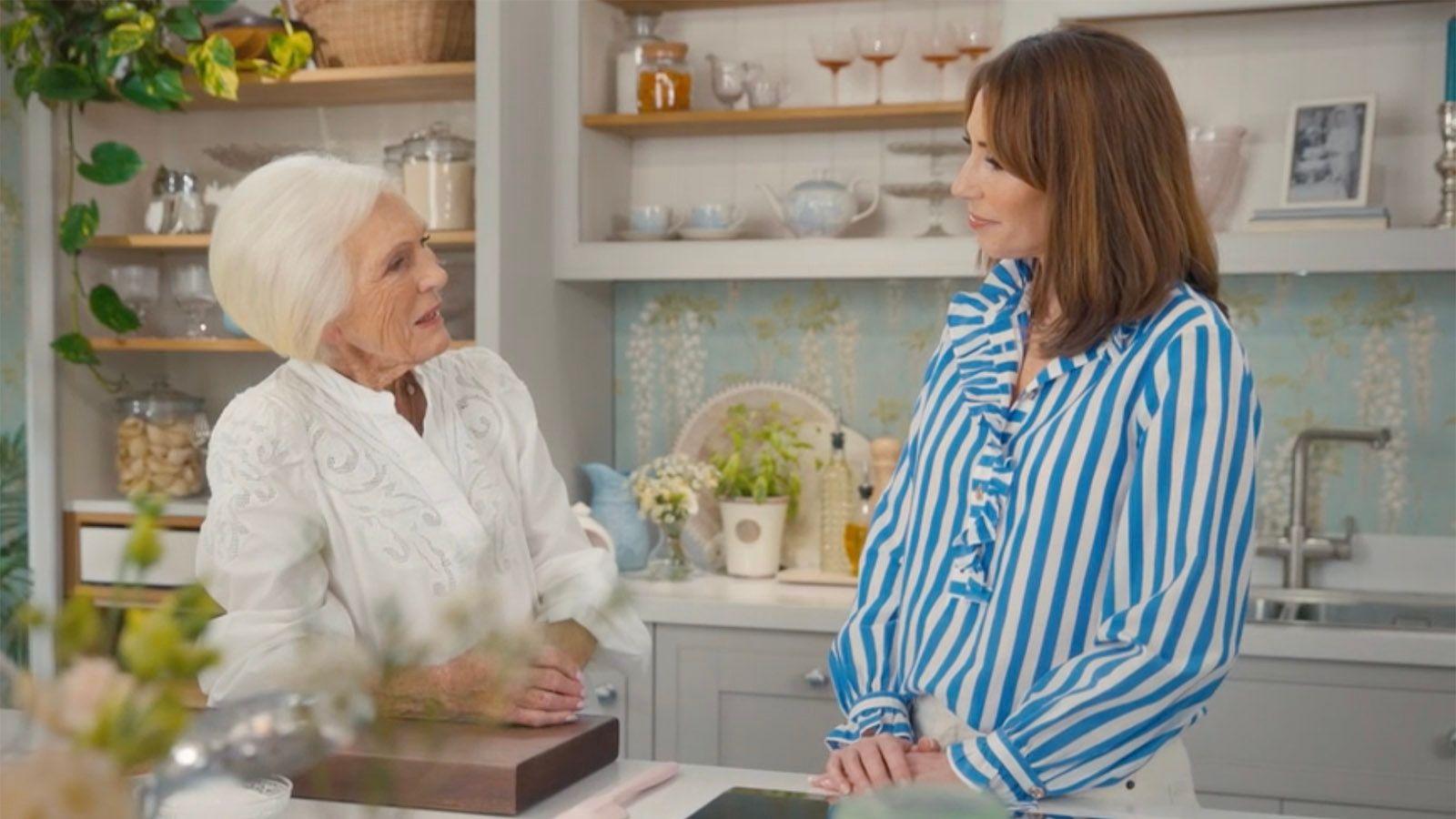 Mary Berry and Alex Jones face each other in a stylised kitchen studio set.