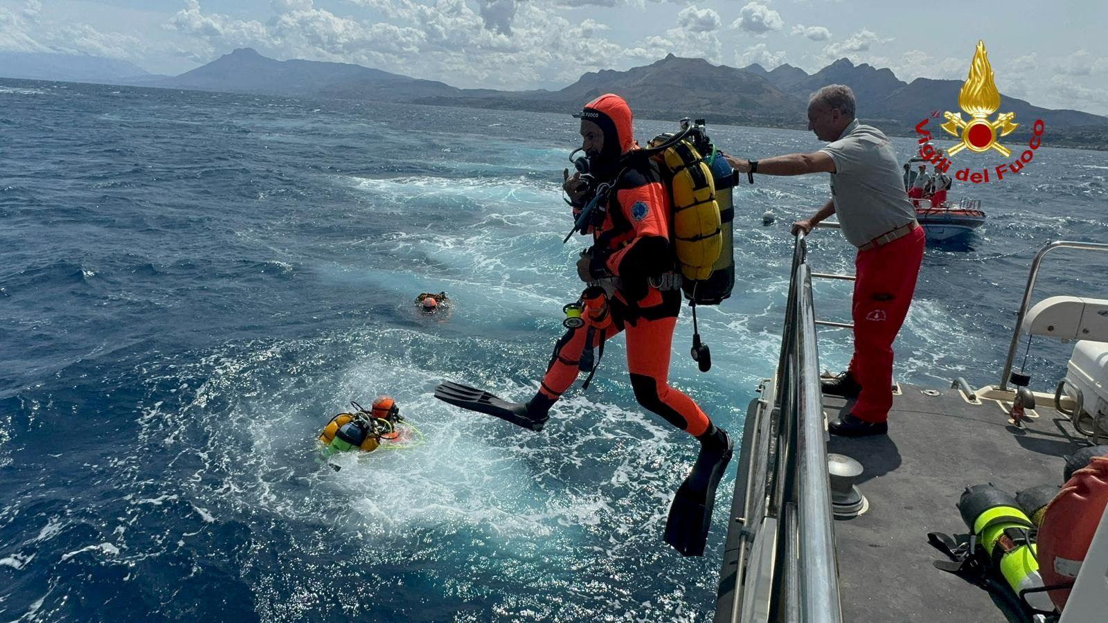 Divers operate in the sea to search for the missing yacht passengers