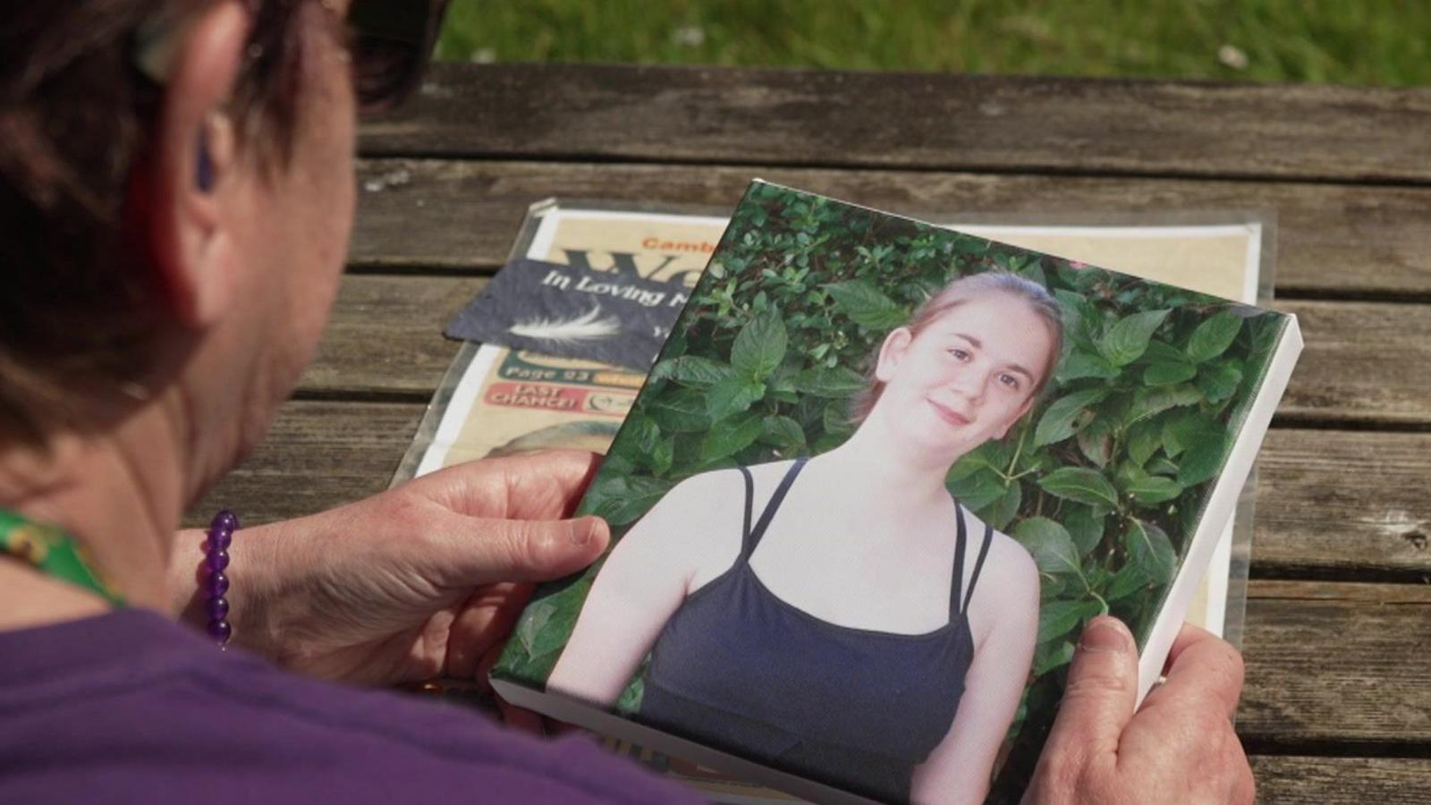 A photo of Julie holding a photo of Hazel